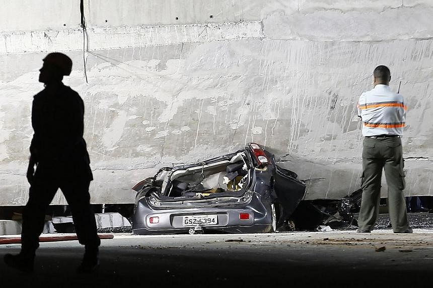 A car is trapped underneath a bridge that collapsed while under construction in Belo Horizonte on July 3, 2014.&nbsp;Rescue workers pulled a body from the wreckage of a collapsed highway overpass in the Brazilian World Cup host city of Belo Horizonte