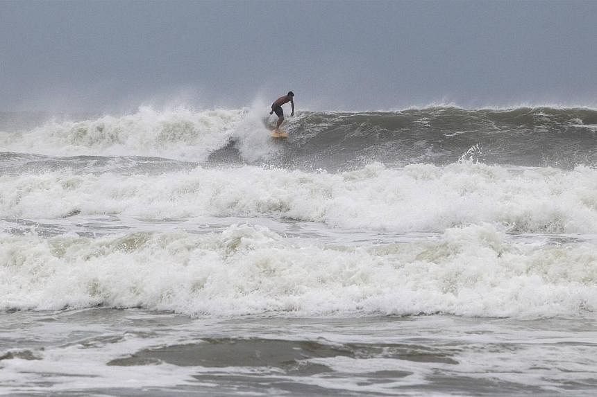 Surfer Ben Powell of Ocean Isle Beach rides a large wave during the effects of Hurricane Arthur, in Ocean Isle Beach, North Carolina on July 3, 2014. -- PHOTO: REUTERS