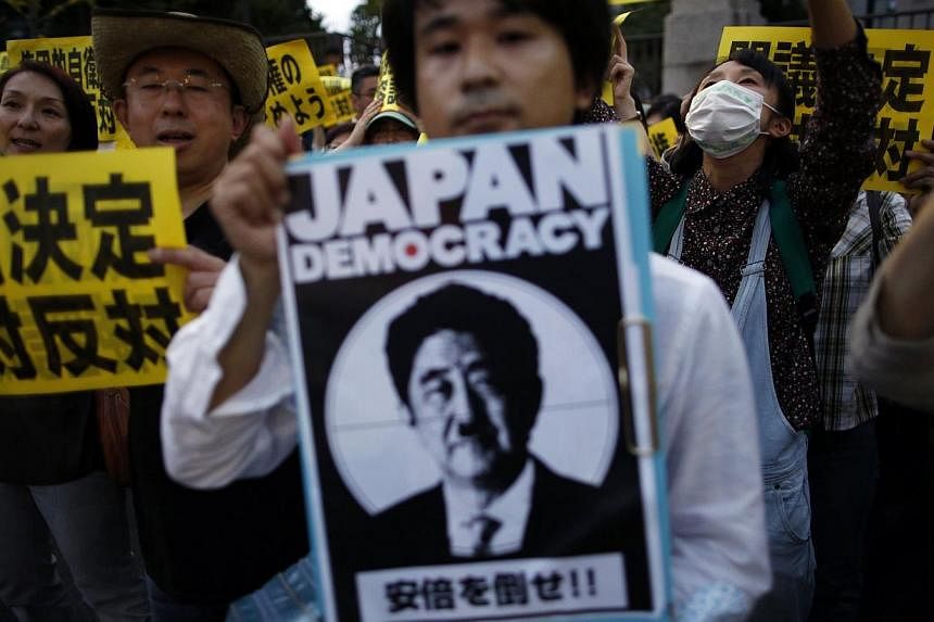 Protesters gather at a rally against Japan's Prime Minister Shinzo Abe's push to expand Japan's military role in Tokyo. On July 1, the Japanese Cabinet decided to "reinterpret" its post- World War II pacifist Constitution by allowing the right to col