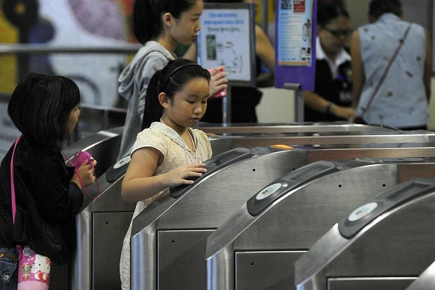 Commuters tapping their EZ-Link cards on the fare gates at Dhoby Ghaut MRT station in 2012. From today till Dec 31, commuters with cards that expire this year - regardless of whether they have been used recently - can get them replaced at any Transit