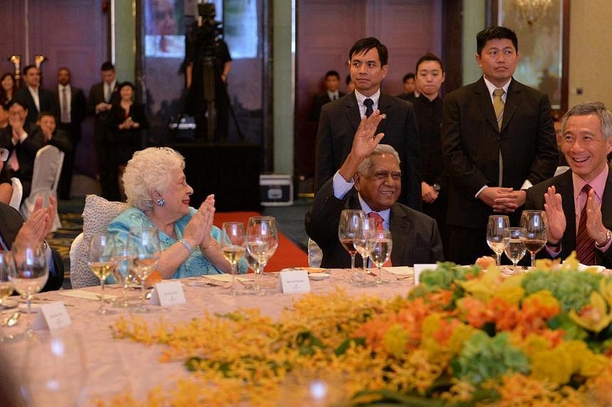 Mr S R Nathan waving as (from left) President Tony Tan Keng Yam, Mrs Nathan and Prime Minister Lee Hsien Loong joined the more than 700 people at the celebration last night at Shangri-La Hotel, in applauding the former president. -- ST PHOTO: CAROLIN
