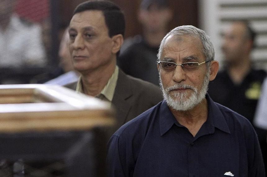Muslim Brotherhood's Supreme Guide Mohamed Badie (right) looks on during his trial at a court in Cairo on May 18, 2014.&nbsp;An Egyptian court sentenced Mohamed Badie to life in prison on Saturday, July 5, 2014, for inciting violence that erupted aft