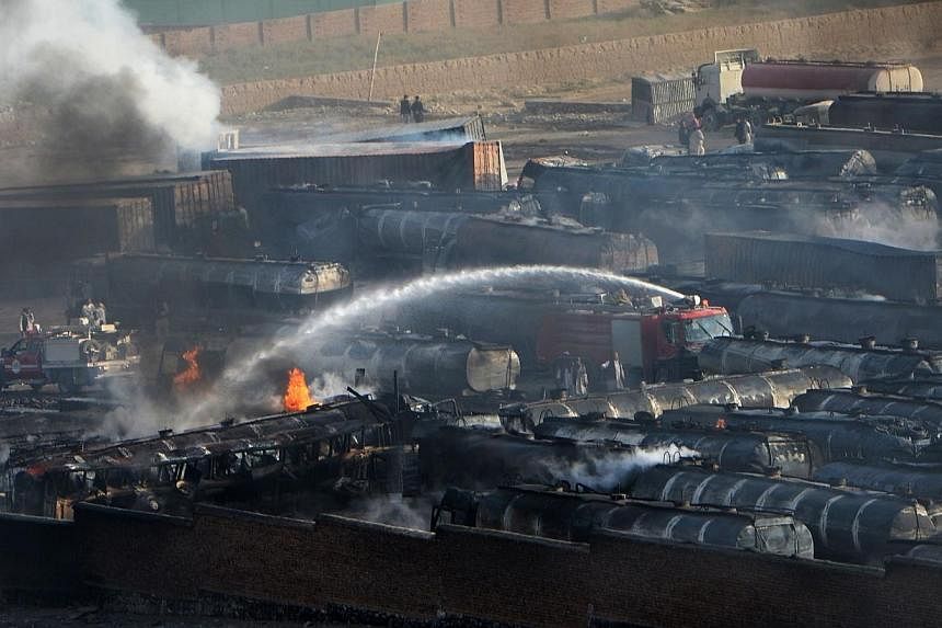 Afghan firefighters attempt to extinguish burning fuel trucks following an overnight attack by Taleban militants in Chawk-e-Arghandi on outskirts of Kabul on July 5, 2014.&nbsp;-- PHOTO: AFP