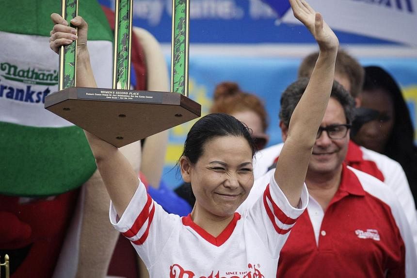 Sonya "The Black Widow" Thomas celebrates her second place finish in the women's division of the 98th annual Nathan's Famous Hot Dog Eating Contest at Coney Island on July 4, 2014 in the Brooklyn borough of New York City. -- PHOTO: AFP
