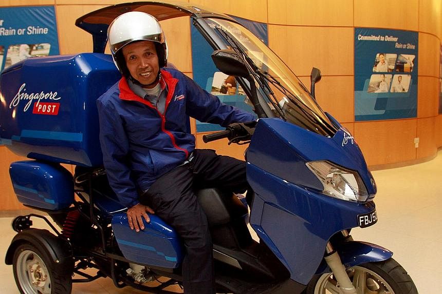 Postman Kamarol Zamal Atan, 50, sitting on SingPost’s new second-generation three-wheeler. Sixty such vehicles, which can hold more parcels, will be deployed in the next three months to help postmen with their loads. -- ST PHOTO: LAU FOOK KONG