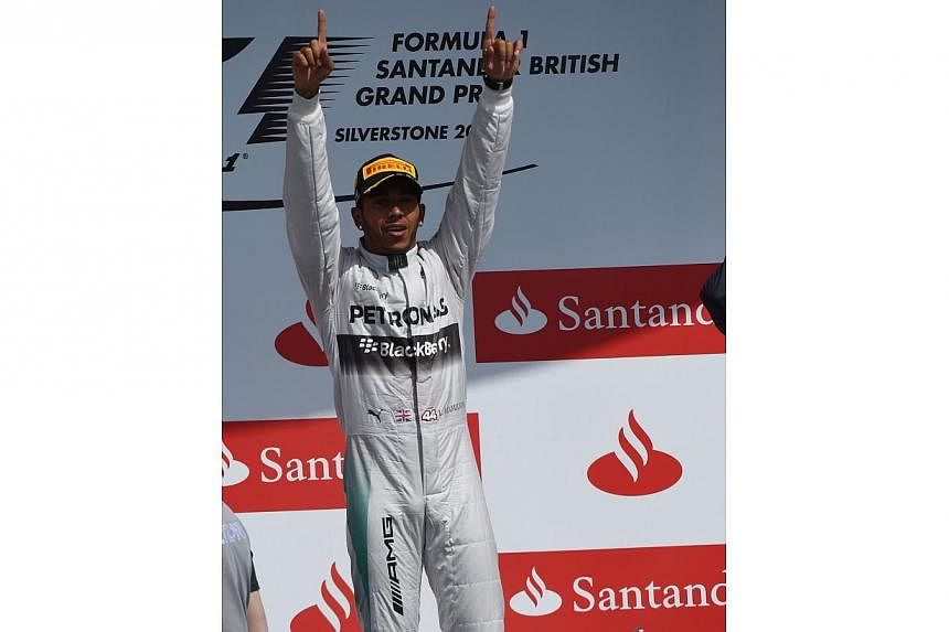 Mercedes-AMG's British driver Lewis Hamilton celebrates on the podium after winning the British Formula One Grand Prix at the Silverstone circuit in Silverstone on July 6, 2014.&nbsp;Lewis Hamilton won his home British Grand Prix on Sunday and slashe