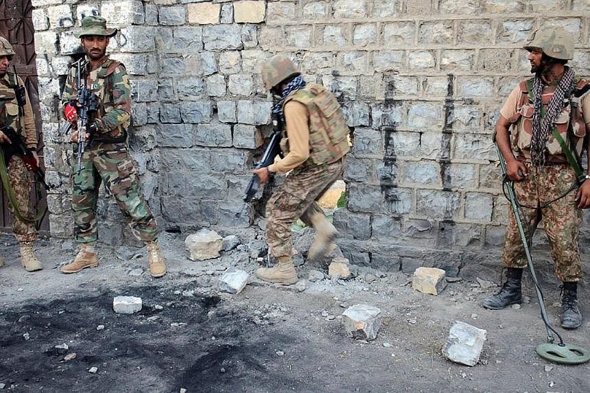 This handout picture released by the Inter Services Public Relations (ISPR) on July 1, 2014, shows Pakistani soldiers entering a house through a hole to search it during a military operation against Taleban militants in the town of Miranshah in North
