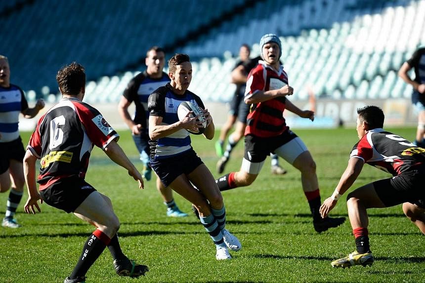 Luke Carpenter (centre) of the Sydney Convicts, an all gay rugby team, runs between Dan Cooper (left) and Peter Bui (right) of Macquarie University at the Allianz Stadium in Sydney on July 6, 2014.&nbsp;Wallabies great John Eales hailed the courage a