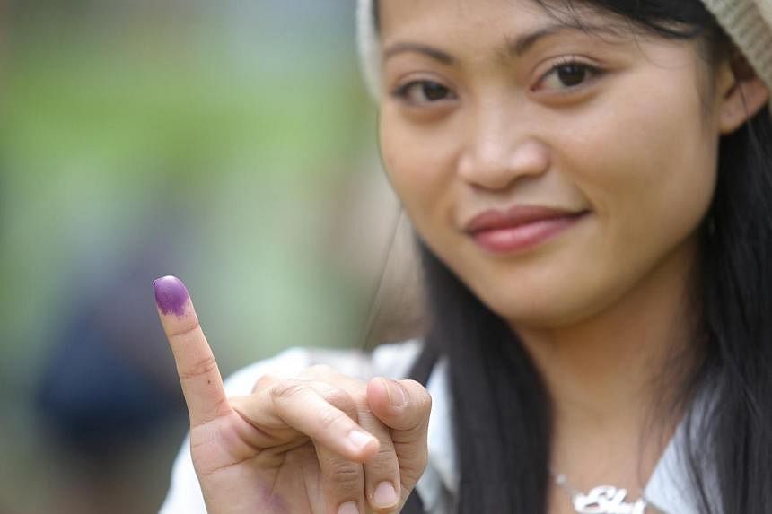 Ekamarliah, 27, a domestic helper, has purple ink on her finger as a mark that she has voted. -- ST PHOTO: ONG WEE JIN&nbsp;