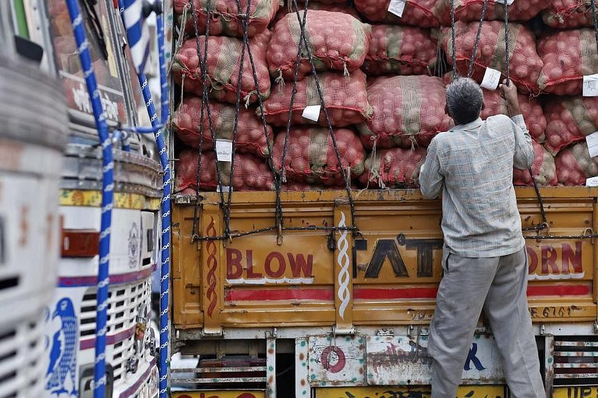 A labourer prepares to unload sacks of potatoes from a truck at a wholesale vegetable and fruit market in New Delhi July 2, 2014. India's new government will seek to raise up to a record $11.7 billion in asset sales in its maiden budget this week, a 