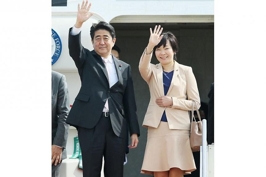 Japanese Prime Minister Shinzo Abe (left), accompanied by his wife Akie, waves as he leaves to New Zealand for his Oceanian tour at Tokyo International Airport on July 6, 2014. Abe started a week-long three nations tour of New Zealand, Australia and 