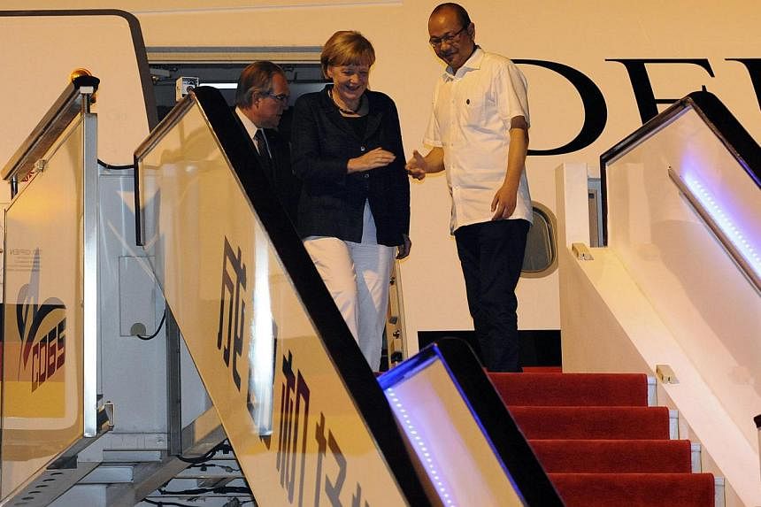German Chancellor Angela Merkel walks out of the aircraft as she arrives at Chengdu Shuangliu International Airport in Chengdu, Sichuan province, early on Sunday, July 6, 2014.&nbsp;Dr Merkel arrived in China on Sunday for her seventh visit since 200