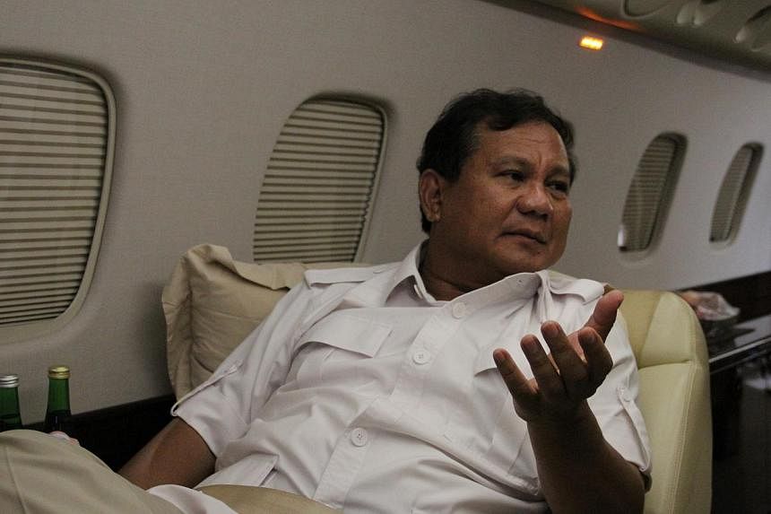 Presidential candidate Prabowo Subianto discusses politics on a private jet to a rally in Semarang, Central Java. He is on the brink of presidency, as surveys now put him within a hair's breadth of his only rival, frontrunner Joko Widodo. -- ST PHOTO