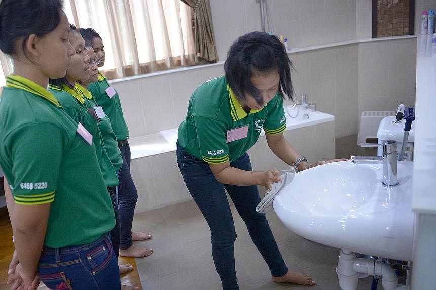 Maids being trained in housekeeping chores at a local agency. As a result of the ongoing price war between agencies, maids now pay recruitment fees of more than $4,000 on average, up from $2,200 previously.