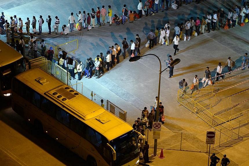 Workers queueing up for buses yesterday at the Tekka Lane bus waiting area, which has been paved over.