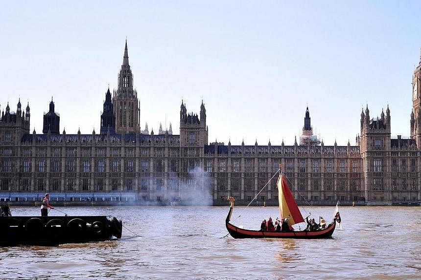 People dressed as a 'Viking warrior-crew' sail along the River Thames near the Houses of Parliament in central London on April 15, 2014.&nbsp;The British government faced growing calls on Sunday for a national inquiry into allegations of child abuse 
