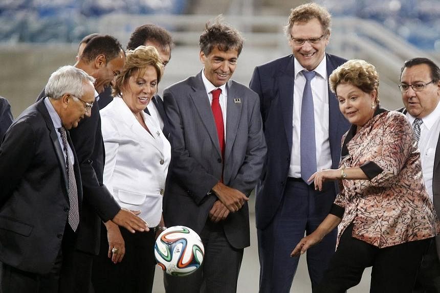 Brazil's President Dilma Rousseff (2nd right) kicks a ball next to FIFA Secretary General Jerome Valcke (3rd right) during the opening ceremony of the Arena das Dunas stadium, which will host 2014 World Cup soccer matches, in Natal, in this Jan 22, 2