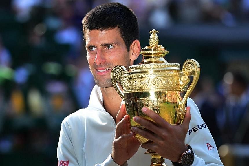Serbia's Novak Djokovic holds the winner's trophy after beating Switzerland's Roger Federer in the men's singles final match during the presentation on day thirteen of the 2014 Wimbledon Championships at The All England Tennis Club in Wimbledon, sout