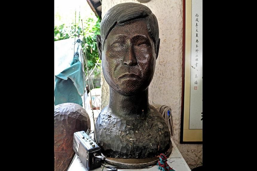 The heads of the nails, burnished over time, create a mottled surface that adds subtle texture, pattern and liveliness to the sculptures, including a large bust (above), a self-portrait. -- ST PHOTO: STEFFI KOH