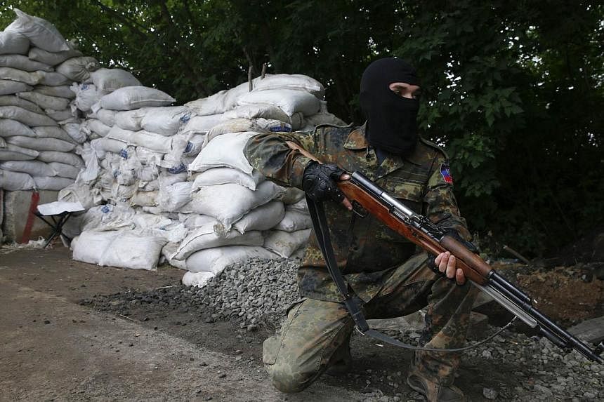 A pro-Russian fighter mans a checkpoint in the eastern Ukrainian city of Donetsk on July 7, 2014. -- PHOTO: REUTERS