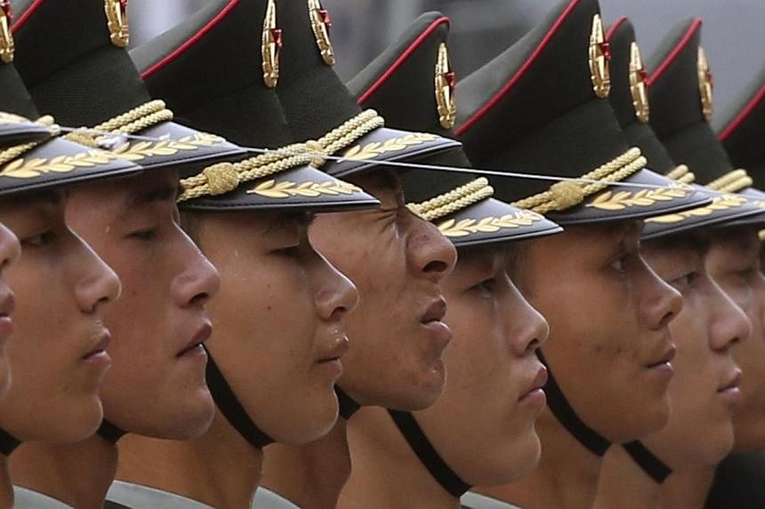 Members of the Chinese PLA honour guard stand behind a string to ensure that they are in a straight line before a welcoming ceremony for Germany's Chancellor Merkel outside the Great Hall of the People in Beijing.&nbsp;&nbsp;-- PHOTO: REUTERS