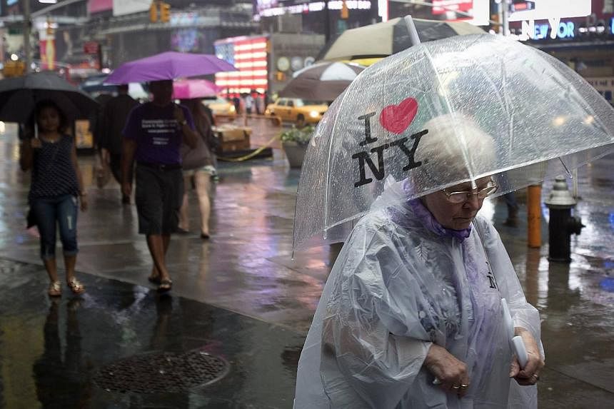People walk in the rain at Times Square in New York on June 9, 2014.&nbsp;Governor Andrew Cuomo on Monday signed a bill making New York the 23rd US state to legalise marijuana for medical use, in a growing momentum. -- PHOTO: REUTERS