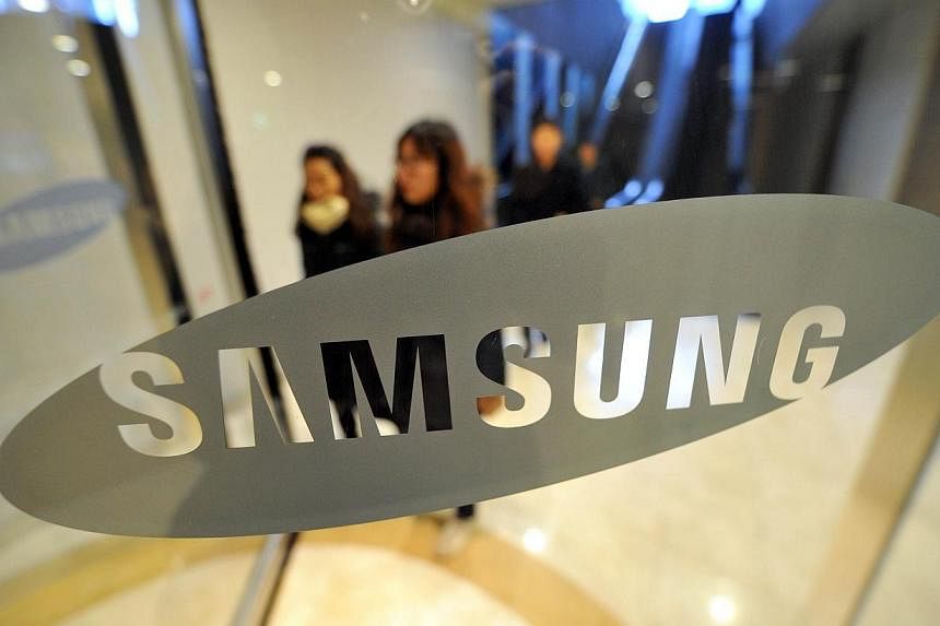 This Jan 24, 2014 file photo shows pedestrians as they walk past a logo of Samsung Electronics at the company's headquarters in Seoul.&nbsp;Around 20 armed robbers raided a Samsung plant in south-eastern Brazil on Monday, leaving with 40,000 smartpho