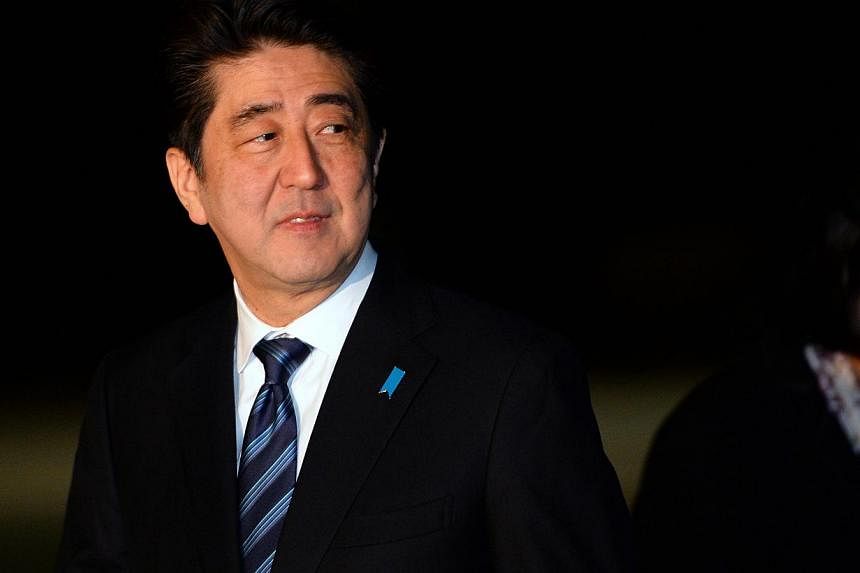 Japanese Prime Minister Shinzo Abe looks back after arriving at the Fairbairn defence establishment in Canberra on July 7, 2014.&nbsp;Japanese Prime Minister Shinzo Abe has played down recent tensions with neighbour China, saying the countries were "