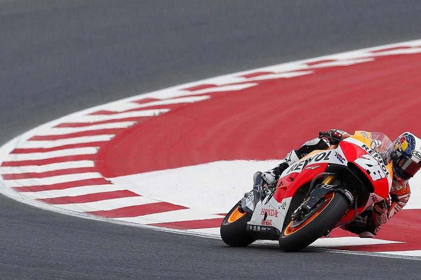 Honda MotoGP rider Dani Pedrosa of Spain takes a curve during the qualifying session at the Catalunya Grand Prix in Montmelo, near Barcelona on June 14, 2014. -- PHOTO: REUTERS