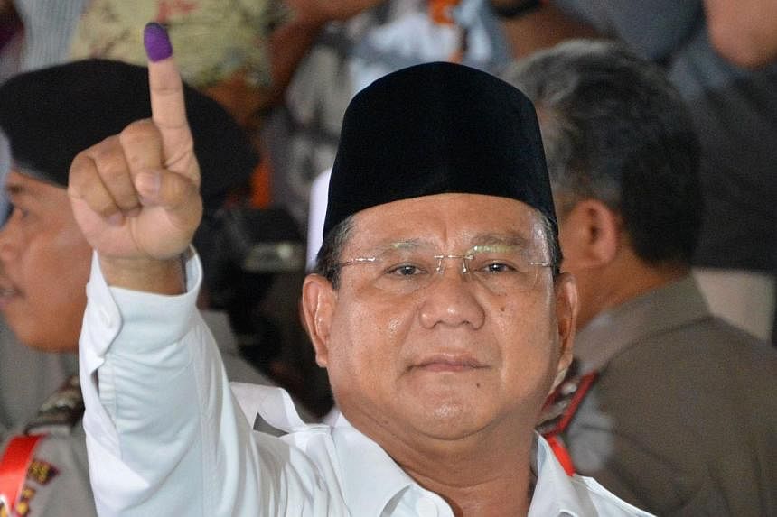 Indonesian presidential candidate Prabowo Subianto displays his inked finger after voting in the country's presidential election at the village of Bojong Koneng in Bogor, West Java province on July 9, 2014. Presidential candidate Prabowo Subianto is 