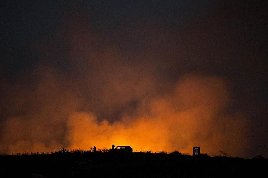 A picture taken in the southern Israeli border with Gaza shows smoke billowing after a mortar attack launched from the Gaza Strip set a bush on fire, on July 8, 2014.