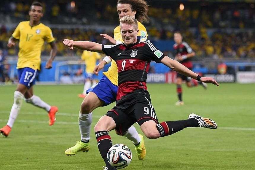 Germany's forward Andre Schuerrle (front centre) kicks to score a goal during the semi-final football match between Brazil and Germany at The Mineirao Stadium in Belo Horizonte during the 2014 FIFA World Cup on July 8, 2014.&nbsp;Germany inflicted a 