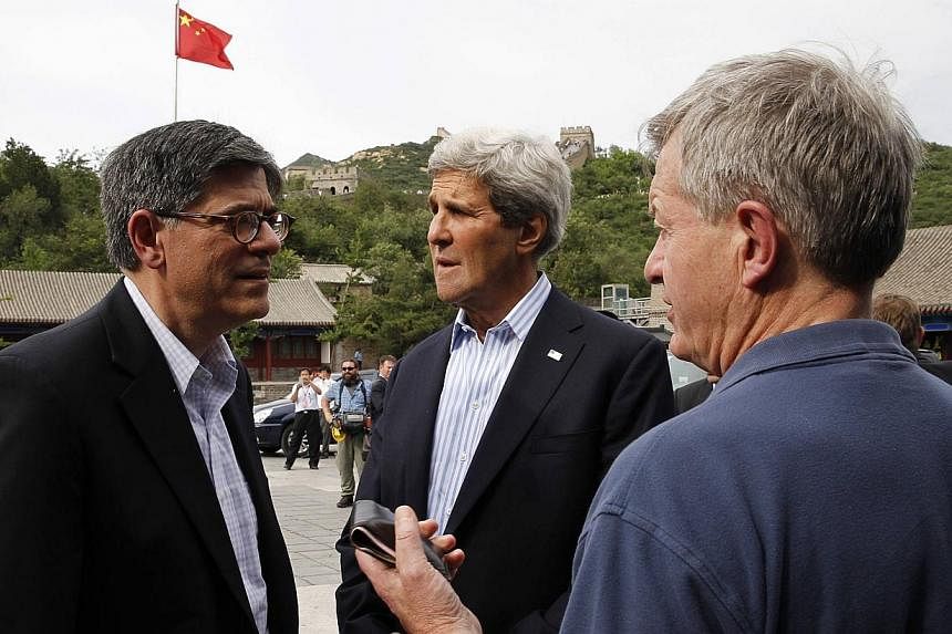 US Secretary of State John Kerry (centre) talks with US Treasury Secretary Jack Lew (left) and US &nbsp;Ambassador to China Max Baucus as they stand in front of a Chinese flag while touring the Badaling section of the Great Wall of China in Beijing, 