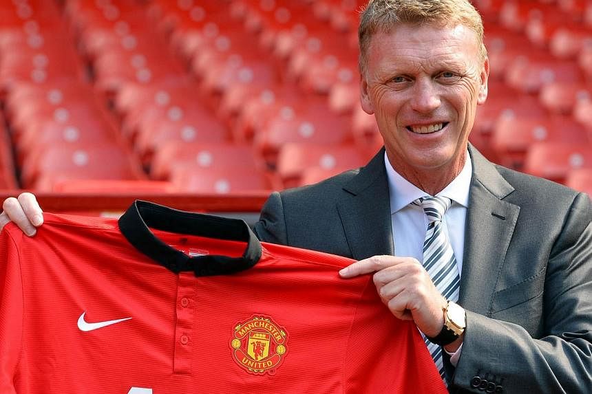 A file picture taken on July 5, 2013, shows Manchester United's Scottish manager David Moyes holding up a club shirt during a photocall at Old Trafford in Manchester.&nbsp;US sporting goods giant Nike said on Tuesday that it will give up it clothing 