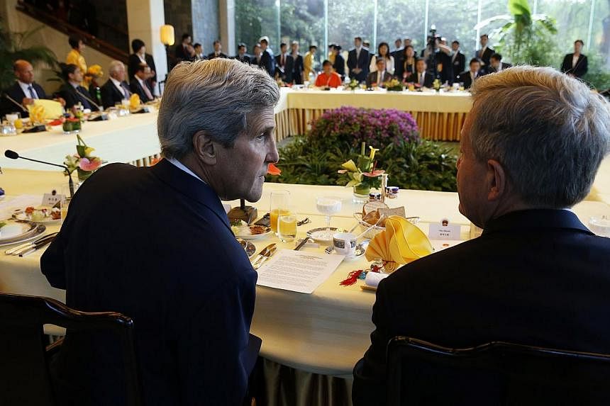 US Secretary of State John Kerry (left) confers with US Ambassador to China Max Baucus as they attend a "CEO Roundtable Breakfast" at the US-China Strategic and Economic Dialogue being held at the Diaoyutai State Guesthouse in Beijing on July 10, 201