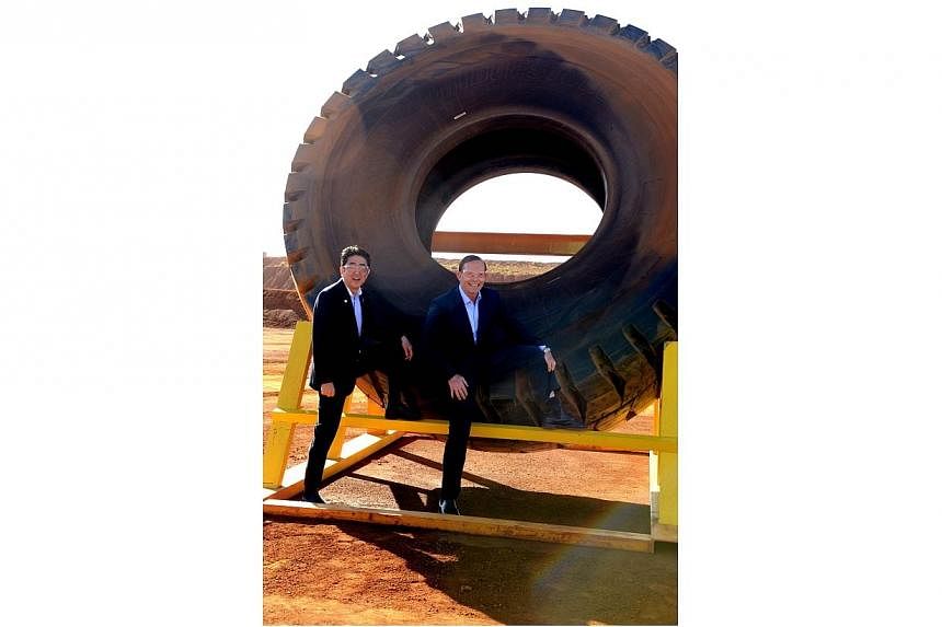 Australian Prime Minister Tony Abbott was taken to task on social media Thursday, July 10, 2014, for tweeting a "cringe-worthy" photo of himself with Japanese counterpart Shinzo Abe posing by a giant tyre. -- PHOTO: AFP