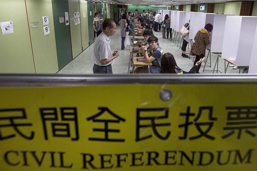Voters are guided inside a polling station during a civil referendum held by Occupy Central in Hong Kong on June 22, 2014.&nbsp;Beijing has slammed an unofficial referendum on electoral reform to be held in the gambling mecca of Macau, local media sa