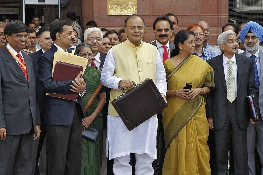India's Finance Minister Arun Jaitley (centre) poses as he leaves his office to present the federal budget for the 2014/15 fiscal year, in New Delhi on July 10, 2014.&nbsp;&nbsp;India’s new right-wing government under Prime Minister Narendra Modi u