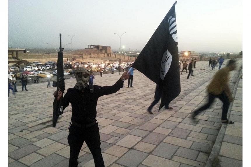 A fighter of the&nbsp;Islamic State in Iraq and Syria&nbsp;(ISIS) holds an&nbsp;ISIS&nbsp;flag and a weapon on a street in the city of Mosul on June 23, 2014.&nbsp;The UN atomic agency said on Thursday, July 10, 2014, that it believed nuclear materia