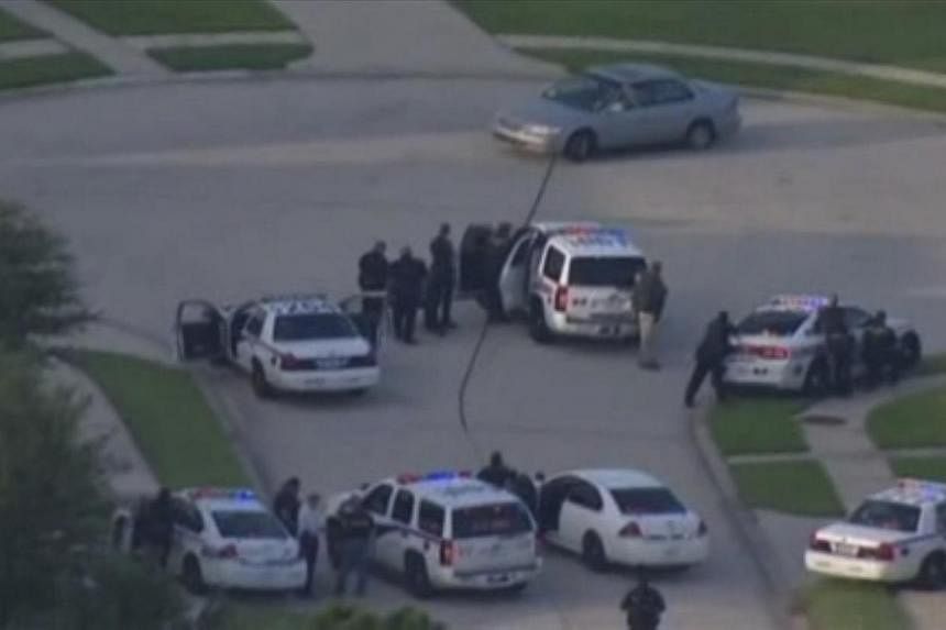 A still image taken from KPRC-TV aerial video footage shows police and a suspect in a standoff at a residential neighborhood following a shooting incident in Spring, Texas on July 9, 2014.&nbsp;A Texas man was charged with capital murder on Thursday,