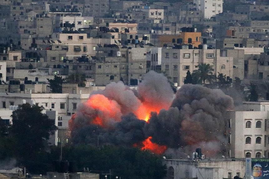 Flames erupt from a building hit by an Israeli air strike on July 9, 2014 in Gaza City. Israeli warplanes pounded Gaza today, killing at least 24 people in a major new confrontation with Palestinian militants, as Hamas flexed its firepower and sent t