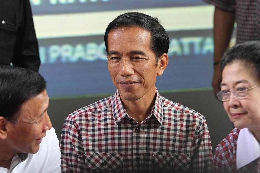 Indonesian presidential candidate Joko Widodo (centre) flanked by former president Megawati Sukarnoputri (right) and former general Wiranto (left), head of the Hanura party, attend a press conference in Jakarta on July 9, 2014.&nbsp;Indonesian stocks