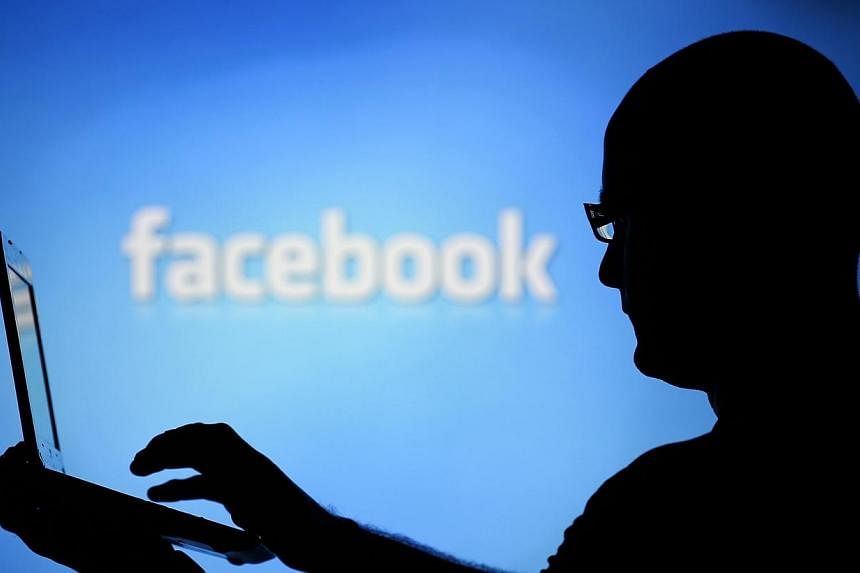 A man is silhouetted against a video screen with an Facebook logo on Aug 14, 2013.&nbsp;Facebook is coming under scrutiny in Myanmar as an unwitting platform for a rising tide of hate speech following a new wave of Buddhist-Muslim bloodshed in the fo