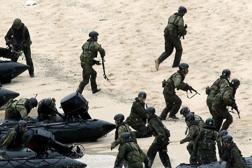 Japan Self-Defense Force (JSDF) soldiers land on Eniyabanare Island during a military drill, off Setouchi town on the southern Japanese island of Amami Oshima, Kagoshima prefecture, in this photo taken by Kyodo on May 22, 2014.&nbsp;Tokyo on Friday, 