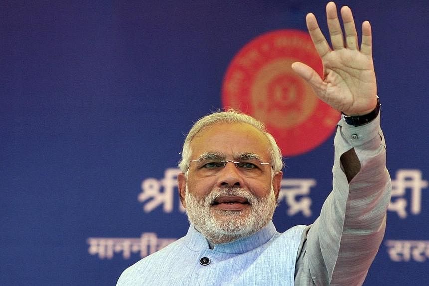 Indian Prime Minister Narendra Modi waves to a crowd at a gathering after inaugurating a train on a new stretch of railway to the town of Katra, north-west of Jammu on July 4, 2014. Mr Modi on Friday, July 11, 2014, accepted an invite to meet US Pres