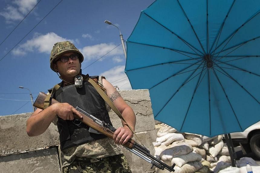 A pro-Russian militia man from the "Russian Orthodox Army" stands at a check point near the airport in Donetsk city on June 10, 2014.&nbsp;Intense battles raged on Friday, July 11, 2014, around the airport in the main stronghold of pro-Kremlin insurg