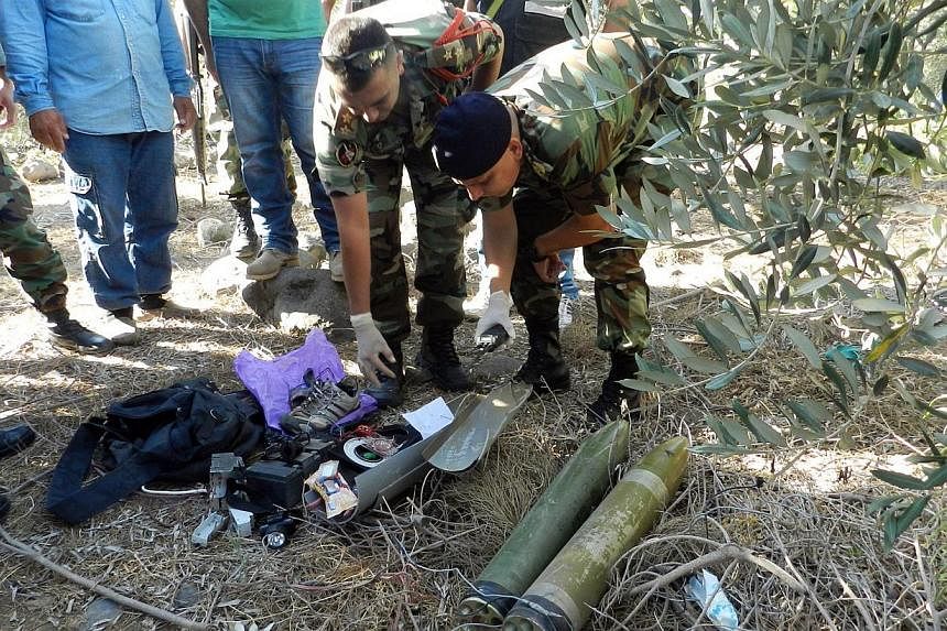 Lebanese Army soldiers dismantle two unfired rockets from their launching site in the area of Majidiyeh, 1km from the Israeli border in southern Lebanon, on July 11, 2014.&nbsp;A rocket fired from Lebanon struck northern Israel early Friday, causing 
