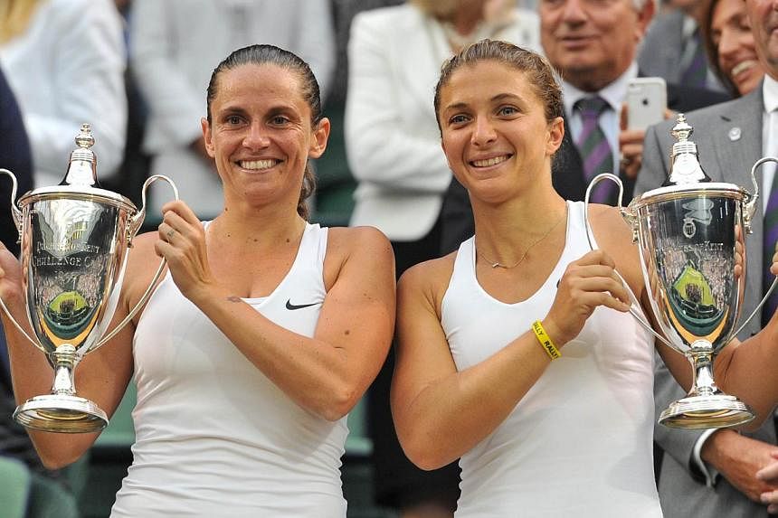 Newly-crowned Wimbledon women's doubles champions Sara Errani (right) and Roberta Vinci have become the first players to qualify for the BNP Paribas WTA Finals Singapore tournament from Oct 17-26. -- PHOTO: AFP