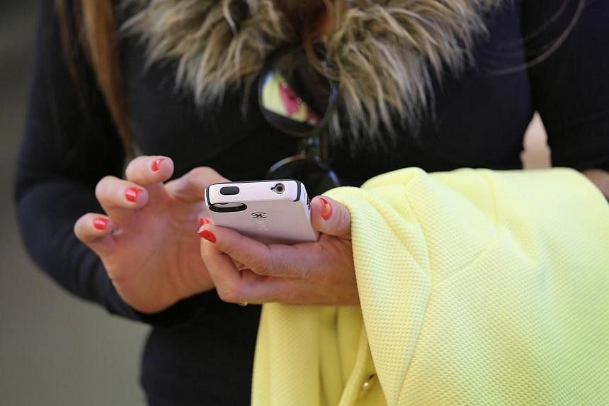 A woman uses an Iphone at Apple's Fifth Avenue store on Earth Day in Midtown Manhattan on April 22, 2014 in New York City.&nbsp;Chinese state broadcaster CCTV has accused US technology giant Apple of threatening national security through its iPhone's
