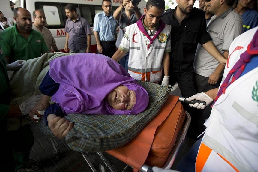 A Palestinian woman is brought into an hospital on a stretcher after she was injured in an Israeli air strike on July 11, 2014 in Gaza City. -- PHOTO: AFP